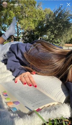 a woman laying down with her head on an open book