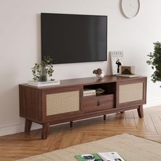 a flat screen tv mounted to the side of a wooden entertainment center in a living room