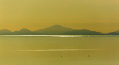 a large body of water with mountains in the background