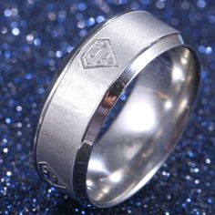 This Is A Stunning Superman-Themed Ring That Will Make A Bold Statement Wherever You Go. The Ring Is Made Of High-Quality Stainless Steel And Features A Detailed Superman Emblem Design On The Top. The Ring Has A Sleek And Modern Design, With A Comfortable Fit For Everyday Wear. Whether You're A Fan Of The Superhero Or Just Love Unique Jewelry, This Ring Is A Must-Have Addition To Your Collection. It's The Perfect Gift For Any Superman Fan Or For Treating Yourself To Something Special. Superman Ring, Steel Superman, Superman Logo, Titanium Wedding Band, Titanium Ring, Mens Accessories Jewelry, Titanium Rings, Mens Band, Silver Band Ring