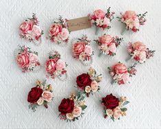 a bunch of flowers that are laying on a tablecloth with a name tag in the middle