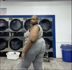 a woman is standing in front of washing machines