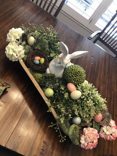 a wooden table topped with flowers and an easter decoration