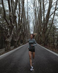 a woman running down the middle of a road