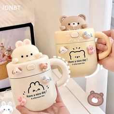 someone holding two mugs in their hands with cute cartoon animals on the inside and outside