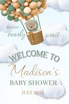 a baby shower sign with a teddy bear in a hot air balloon flying through the sky