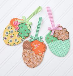 three handmade tags are hanging on a white table with pink, green and orange ribbons