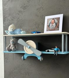 two shelves with toys on top of them and one shelf holding a baby's picture