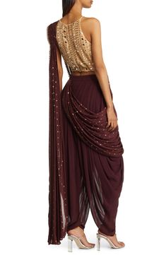 Elegance is achieved in an enticing outift that includes a midriff-baring top, dance-all-night dhoti pants and an attached dupatta that's easy to drape. The booti-work drape is attached to the outfit, so you don't have to worry about pleats or the right draping—just wrap it around and over your shoulder. 27" inseam, 11"l leg opening, 16" top (size medium) Halter neck Spaghetti straps On-seam pockets Pants and drape feature hook-and-eye attachments for easy adjustments Lined 100% viscose Spot cle Indian Pants, Pretty Pants, Modern India, Burgundy Pants, India Style, Coverall Jumpsuit, Dhoti Pants, Bearded Lady, Resort Outfit