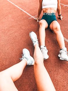 two women sitting on the ground with their legs crossed