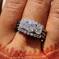 a woman's hand with a ring on it and two diamonds in the middle