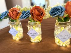 three mason jars with flowers in them on a table