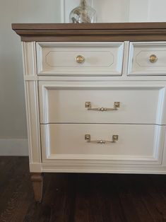 a white dresser sitting on top of a wooden floor