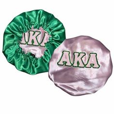 two green and white satin hair scrunffs with the letters aka on them