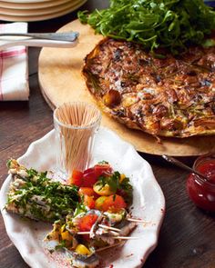 a plate that has food on it and some other plates in the background with utensils