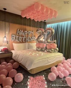 a bedroom decorated with balloons and streamers in the shape of two twenty birthday candles