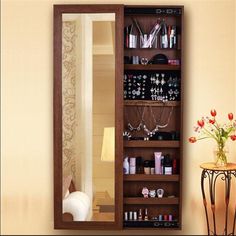 a large mirror sitting on top of a wall next to a shelf filled with jewelry