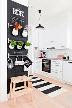 a kitchen with black and white decor on the wall