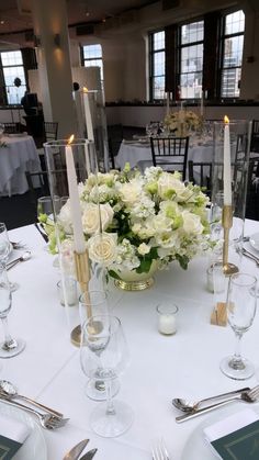 the centerpieces on this table are all white and have gold trimmings