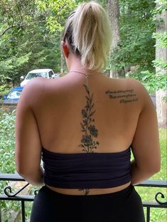 the back of a woman's body with tattoos on her upper and lower back