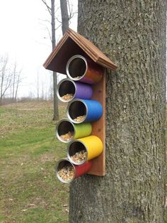 a bird house that is hanging on the side of a tree with birds in it