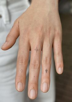 a woman's hand with a tiny star tattoo on it