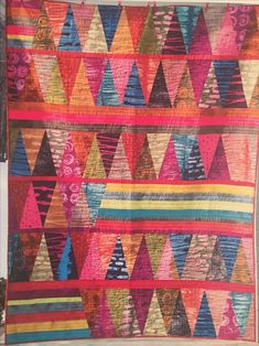 a colorful quilt hanging on the wall