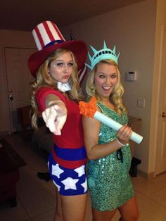 two women dressed up as the statue of liberty and one holding a baseball bat in her hand