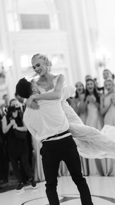 a bride and groom dance together in front of their wedding party at the grand america hotel