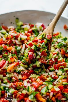 a pan filled with chopped vegetables and a wooden spoon sticking out of the top one