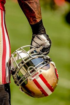 a close up of a football player's helmet with tattoos on his arm and leg