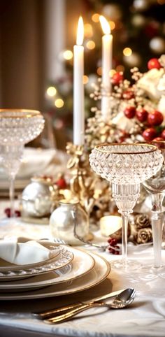 a table set for christmas dinner with silverware and candles in the centerpieces