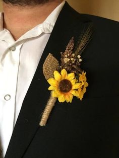 a man wearing a black suit with a sunflower boutonniere on it