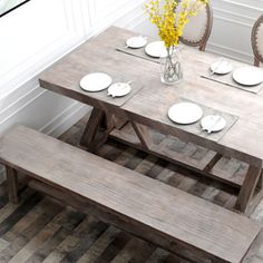 a wooden table with two benches and plates on it