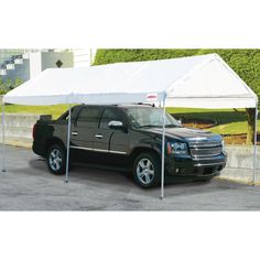 a black truck parked under a white tent