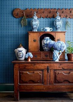 blue and white vases are on top of an old dresser