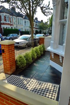 a black and white checkerboard sidewalk in front of a house