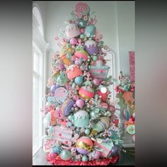 a decorated christmas tree in the corner of a room with lots of ornaments on it