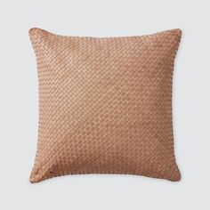 a brown pillow with a woven design on the front and back, sitting against a white background