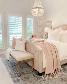 a bedroom with a bed, chair and chandelier