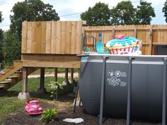 a backyard with a pool, slide and play set in it's back yard