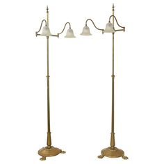 two brass floor lamps with white glass shades