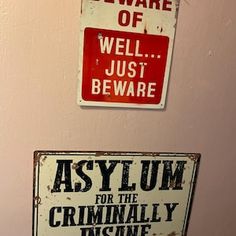 two signs are hanging on the wall next to each other