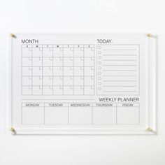 a white calendar hanging on a wall with the words, month and week written in it