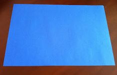 a piece of blue paper sitting on top of a wooden table