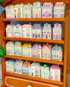 a wooden shelf filled with lots of little houses on top of it's sides