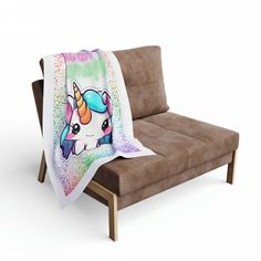 a couch with a blanket on it that has an image of a unicorn in the background