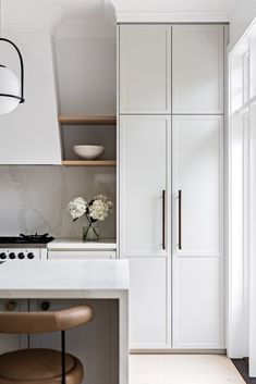 a kitchen with white cabinets and counter tops