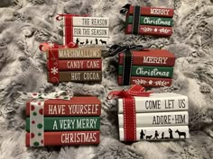 four christmas gift wrapped in red, green and white wrapping paper on a fur surface