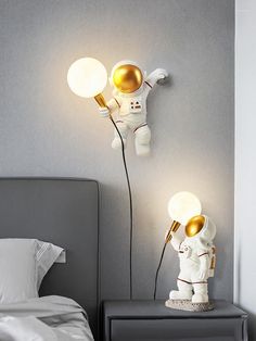 an astronaut lamp is next to a bed